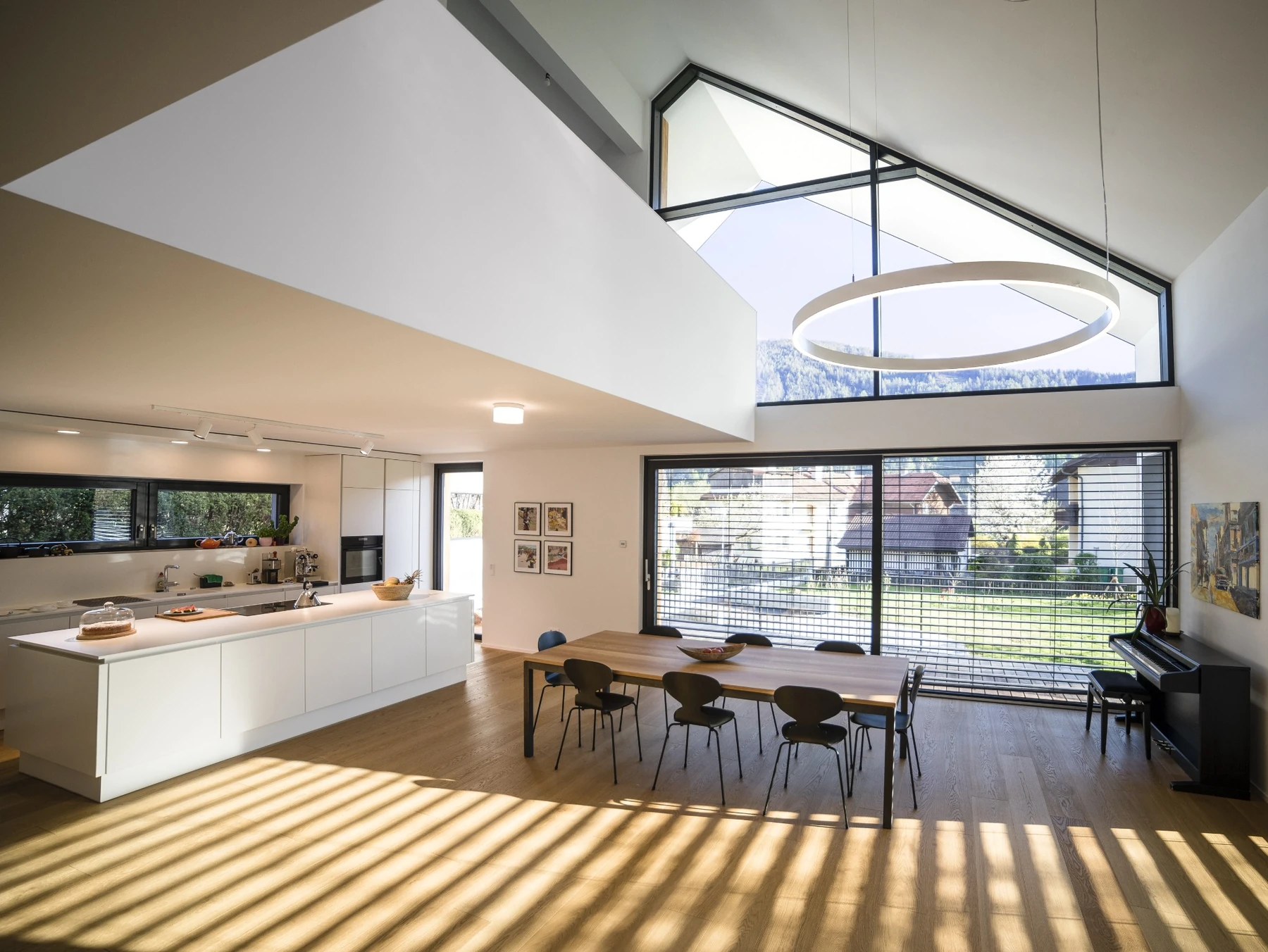 Lichtdurchfluteter Wohnraum mit hohen Decken, großen Fenstern und klarer Architektur